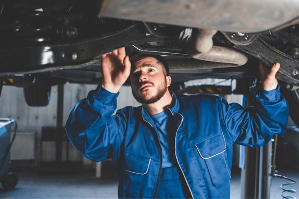 car inspection by mechanic blue jumpsuit